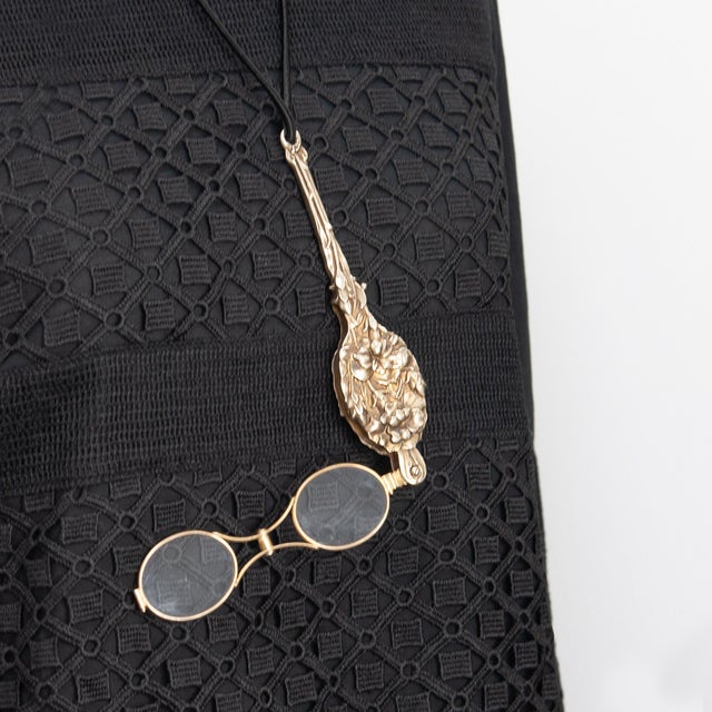 An exquisite antique Art Nouveau lorgnette, circa 1900s by Unger Brothers, featuring a silver vermeil repoussé handle and...