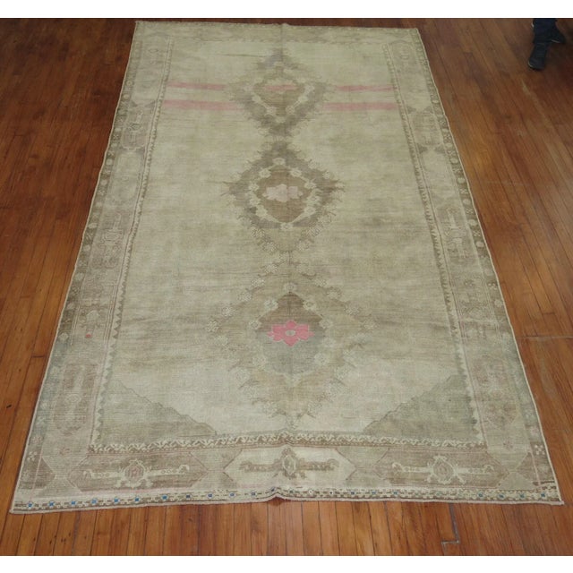One of a kind, mid 20th-century Hand-knotted Turkish rug in gallery size format in neutral colors with pops of pink....