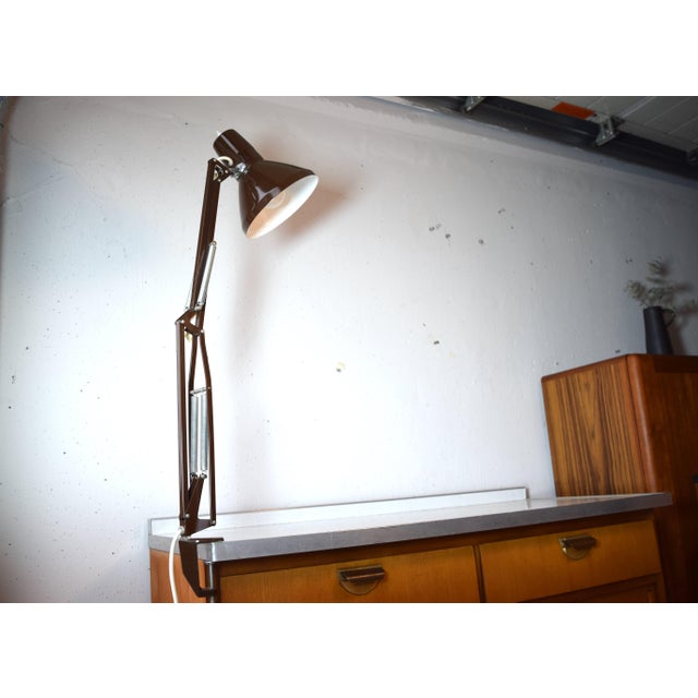 This is an articulated desk lamp in an architect's style from the 1970s. The lamp is mounted directly to the tabletop at...