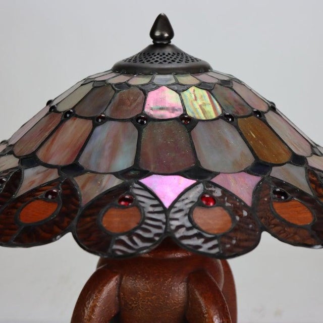 This distinctive table lamp embodies the enduring appeal of the Arts & Crafts movement, featuring a meticulously crafted...