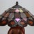 This distinctive table lamp embodies the enduring appeal of the Arts & Crafts movement, featuring a meticulously crafted...