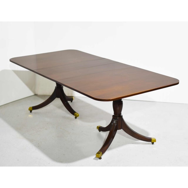 This handsome vintage dining&nbsp;table in&nbsp;the style of Duncan Phyfe features a classic silhouette. Crafted from...