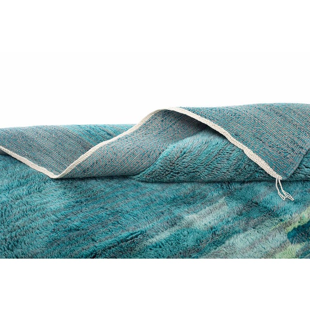Where stone meets sea, captured in wool. This piece unfolds like a coastal horizon, a mottled field of odyssey grey, sage...