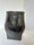 This striking, sculptural pottery vase captures the beauty of the handmade. Its fluid form and rich, ebony tones...