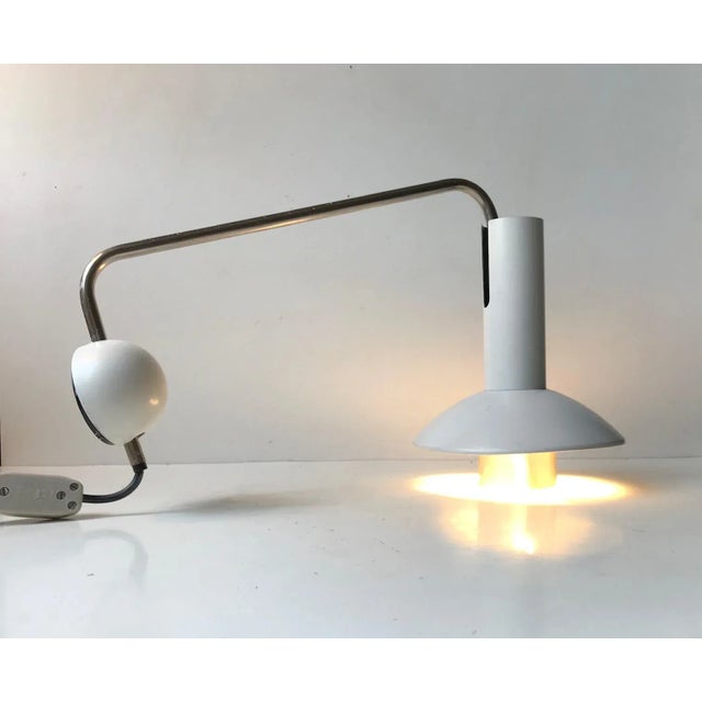 A rare white wall light designed and manufactured by Louis Poulsen in Denmark during the 1970s. This model - 132051 is...