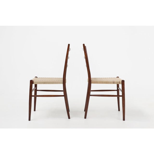 Beautifully designed teak dining chairs with curved back with bars, slender legs and braided rope seat. The teak wood...