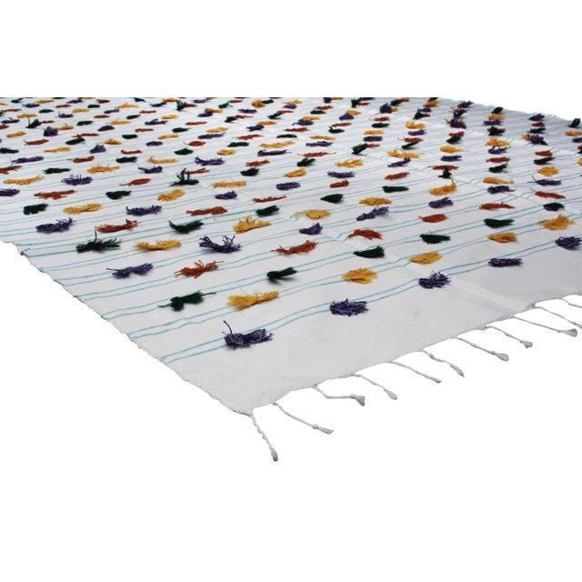 Vintage Berber blanket handmade in the High Atlas Mountains of Morocco. Featuring blue stripes and colorful pile tufts,...