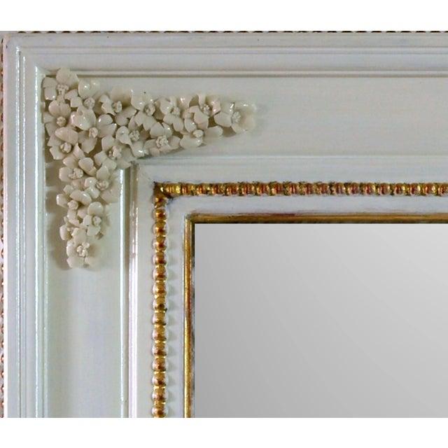 White lacquered frame mirror with gold leaf gilded finishes and white roses handmade decorations in pure Capodimonte...