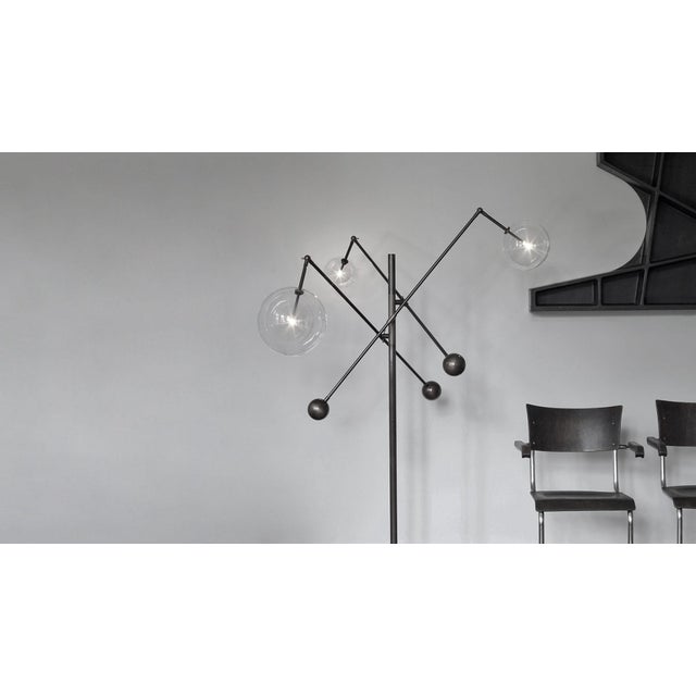 Three mouth-blown spheres upon cantilevered arms create an adjustable interplay of geometric angles. A free-standing lamp...