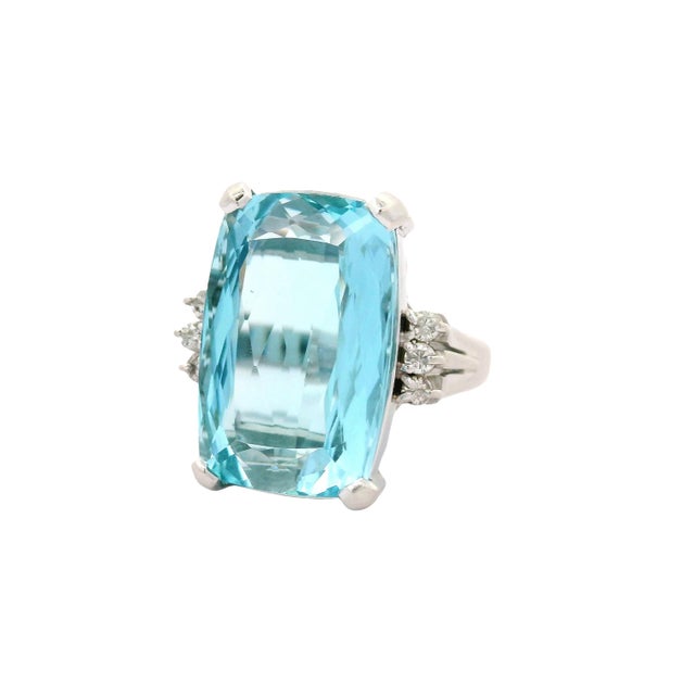 A striking cocktail ring showcasing a magnificent aquamarine weighing 10.25 carats. The cushion stone radiates a...