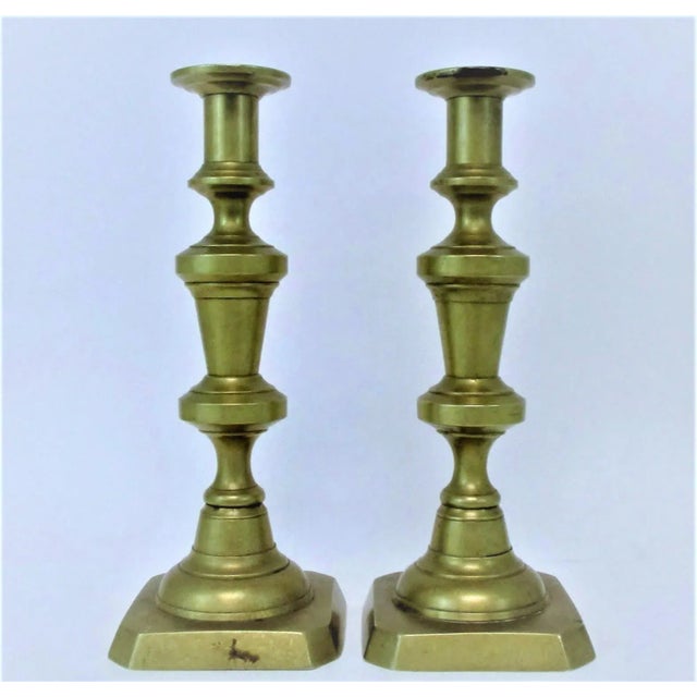 Vintage brass candlesticks with English styling. Each uses one regular taper and has original push ups. Left in unpolished...
