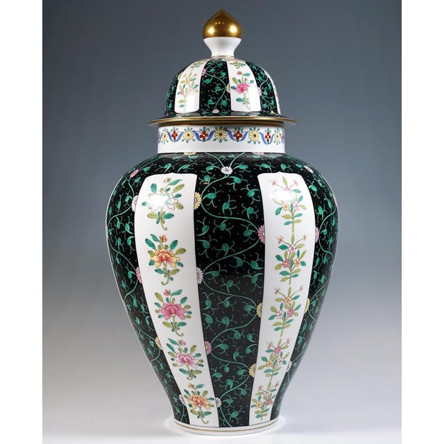 Very large urn-shaped vase with a lid; a bulging, tapered body standing on a flush stand with a straight, superimposed...