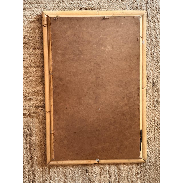 Vintage wall mirror made of natural bamboo, dating from approximately 1950 or 1960. It features a classic frame with...