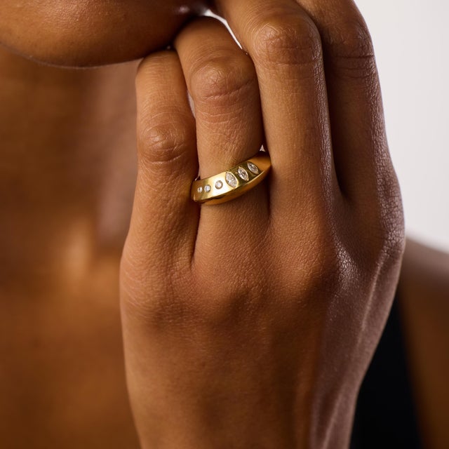 This elegant vintage band showcases a graceful combination of marquise and round brilliant cut diamonds totaling...