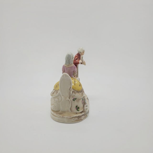 Vintage porcelain figurine depicts a courtly musical scene featuring a man playing the violin and a woman seated at a...