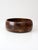 This vintage mid-century wood bowl features a low, rounded form crafted from joined sections of richly varied wood....