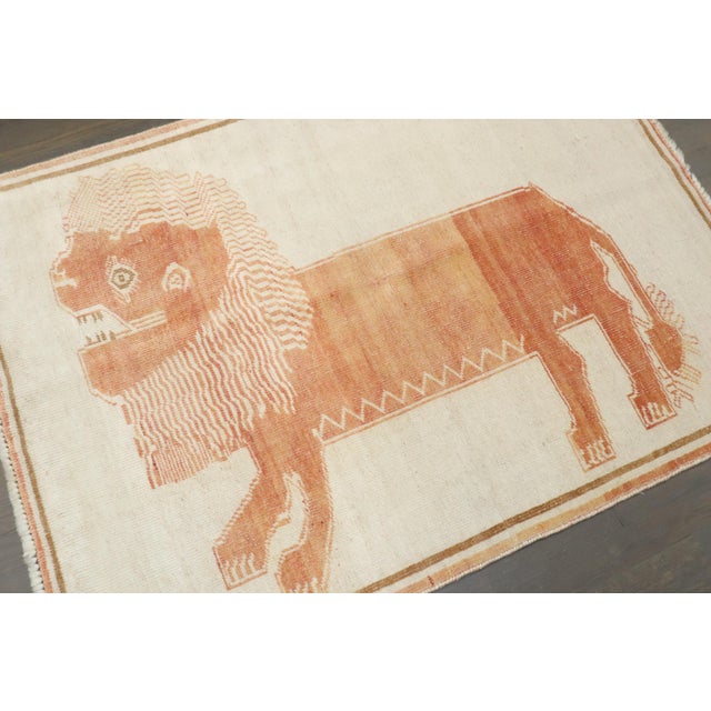 a mid-20th-century Persian Gabbeh with an apricot colored lion on an ivory colored ground Details rug no. j4470 size 3' 3"...