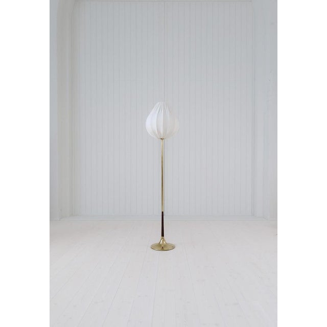 A gorgeous floor lamp made in brass with a trumpet shape like structure. The patinated brass parts gives a wonderful look...