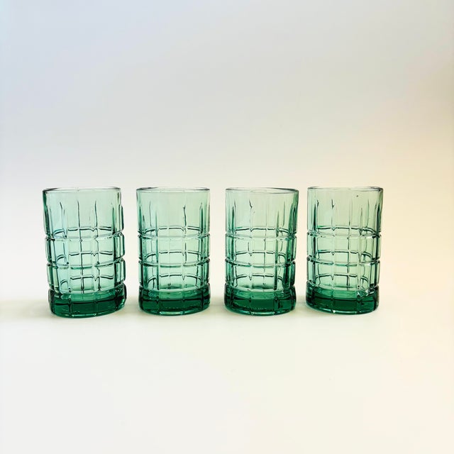 A set of 4 vintage tumblers. Made of thick glass in a beautiful muted bluish green color with a gridded design. Made in...