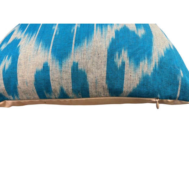 A sky blue silk ikat cover with a visible abraj running across the field — a natural tonal shift in the ground color that...