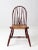 This antique Windsor chair features a beautifully aged wooden frame with a classic brace-back design, turned splayed legs,...