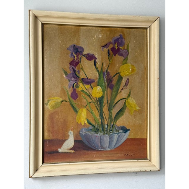 A Spring study of purple irises and yellow tulips in oil on board from the first half of the 20th century. The flowers are...
