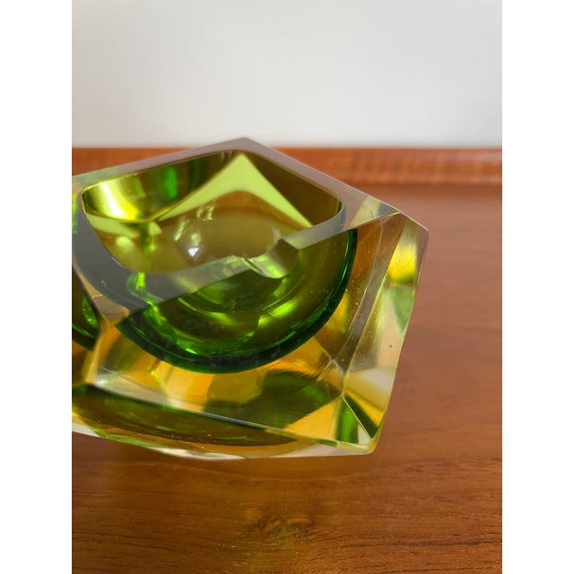 A striking vintage Mandruzzato Murano glass ashtray featuring a deep green center surrounded by amber and thick clear...