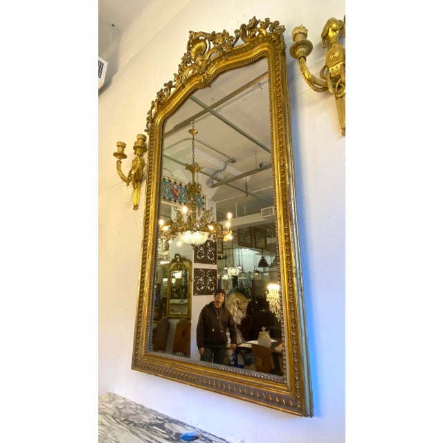 Gold gilded French antique wall or floor mirror with shell, foliate, and beaded designs. One available. The manufacturer...