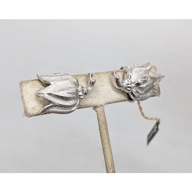 1950s textured rhodium plated tulips clip earrings. Marked "TRIFARI" on the clips. Measure: 5/8 inches tall by 1 inch...