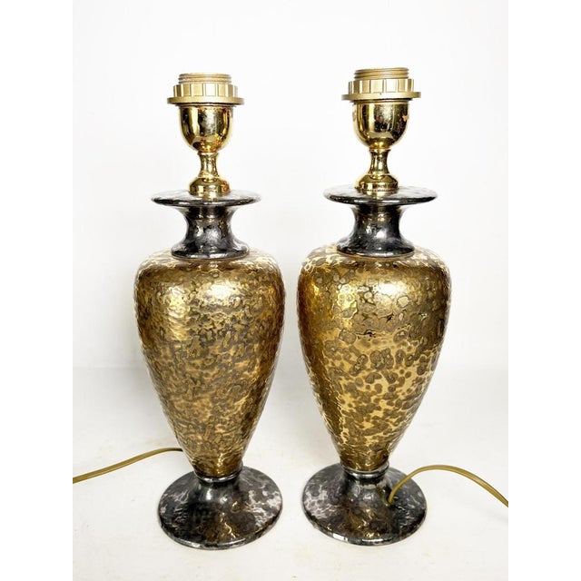 Pair of vintage hammered gold metal lamps, typical of 1980s decorative design. Their vase-shaped base features an...
