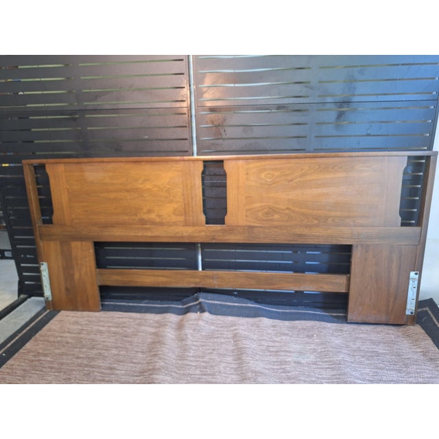 This vintage mid-century modern walnut headboard features distinct geometric cutouts and classic warm wood grain.