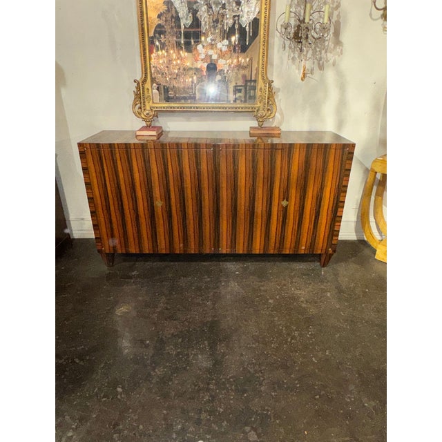 The Italian Art Deco Style Zebrawood Sideboard is a luxurious and stylish piece of furniture that adds a touch of...