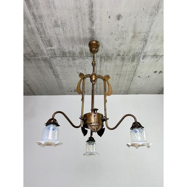 Art Nouveau three-arm chandelier with opal iridescent glass in excellent condition. Up to 250V (Europe/UK Standard).The...
