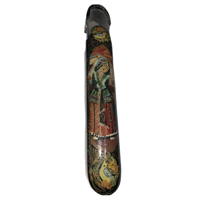 A polychrome lacquer papier mache pen case. Qajar 20 century. With rounded ends and sliding tray, decorated all over with...