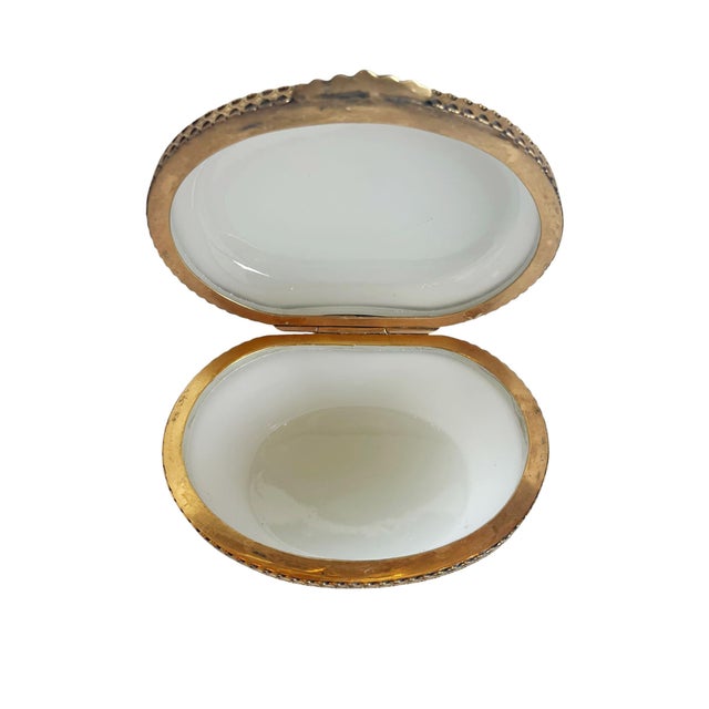 A charming 19th century French opaline glass box featuring a soft white opaline body accented by an elegant gilt metal...