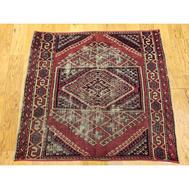 This near-square antique Turkish village rug is a striking example of Anatolian craftsmanship, showcasing a bold geometric...