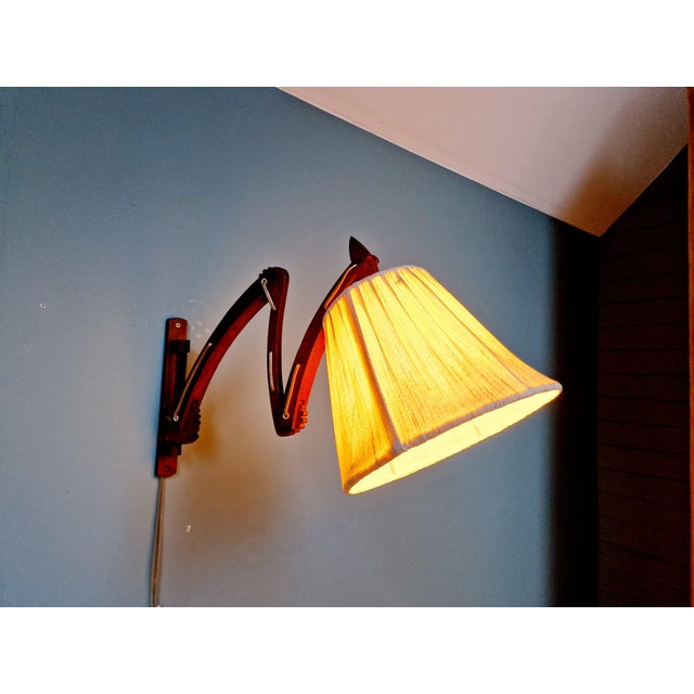 Teak scissor wall light with a cream fabric shade, Scandinavian design from the 60s. The wall lamp can be rotated 180° at...