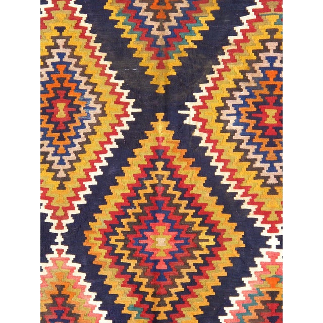 This vintage Turkish kilim is crafted from soft lamb's wool and features a striking navy and red color palette. The...