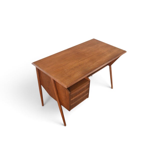 This desk was designed by G. Tibergaard Nielsen and produced by Tibergaard in Denmark during the 1960s. The teak case...