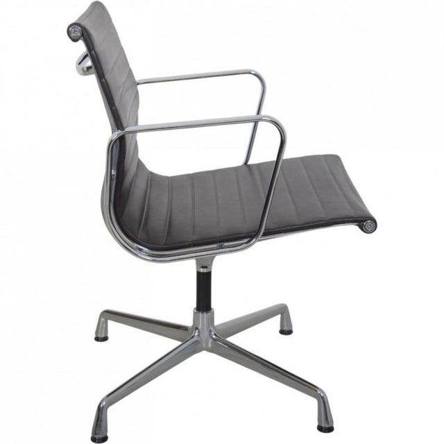 Charles Eames Ea-108 office chair upholstered in dark brown leather and with chrome armrests and frame. The chair is from...