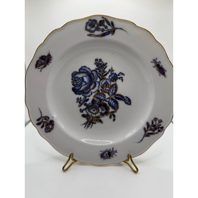 Twelve antique gilt rimmed Meissen porcelain dessert dishes with blue and gold floral and insect decoration. Each piece...