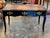 An elegant Early 19th Century French ebonized bureau plat with a warm, well-worn leather writing surface set within a...