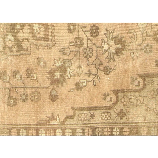 This vintage Turkish Oushak rug, measuring 7'5" x 10'10", is handwoven with wool on a wool foundation in the Oushak region...