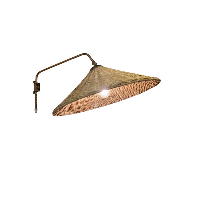 This vintage wall lamp, made by Valinte in the 1950s, beautifully combines brass and rattan into a warm and inviting...
