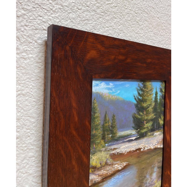 Mountain Waters captures a serene landscape where a tranquil stream meanders through a lush setting, framed by tall...