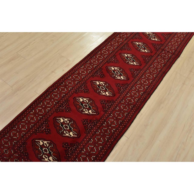 An authentic vintage tribal Turkmen runner, hand-knotted with fine wool and natural dyes. This nomadic rug features a row...