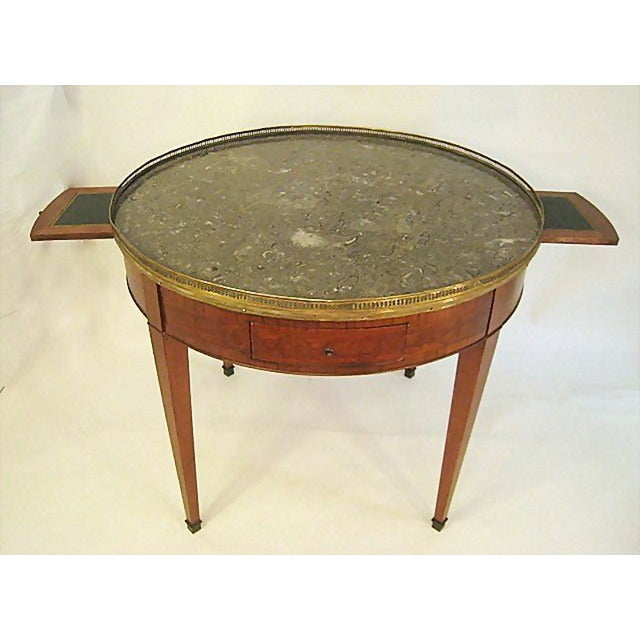Elegant French round gueridon or bouillotte table with a brass gallery and intact gray marble top. Rare—unusually large...