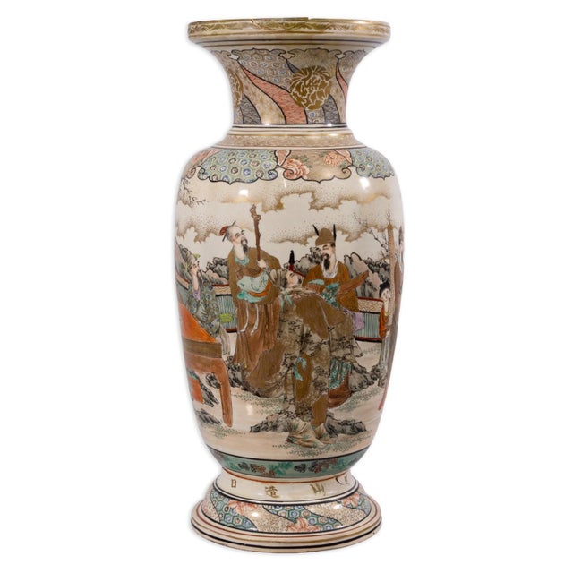 A Japanese Satsuma vase features intricate hand-painted decoration in richly enameled and gilt detail. The body is adorned...