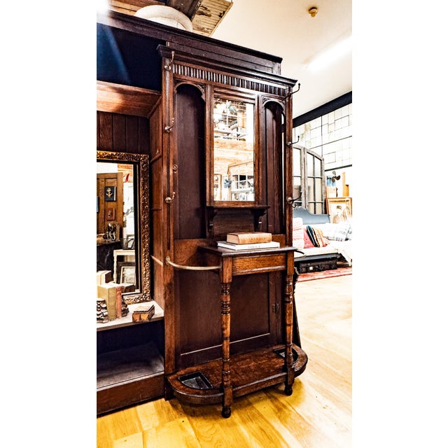 A lovely Edwardian walnut hall tree with six brass hooks, charming carvings, and a storage box with lift up lid.