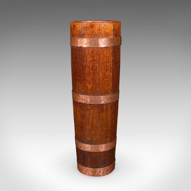This is an antique coopered stick loop. An English, oak and copper country house umbrella stand, dating to the late...